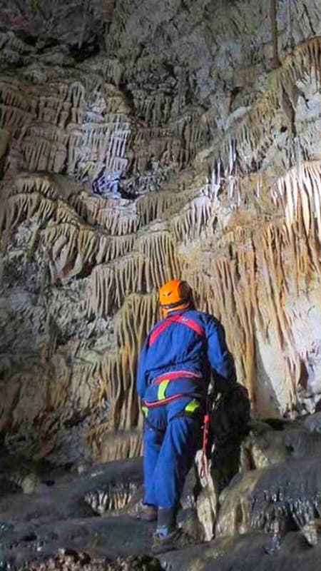 Grupo de personas con cascos y frontales explorando una cueva natural en Venta del Moro.